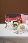 Elevated view of place setting with flowers and a bun — Stock Photo