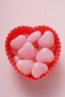 Ansicht von rosa herzförmigen Bonbons in roter Schale — Stockfoto