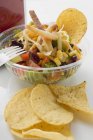 Mexikanischer Salat mit Tortilla-Chips zum Mitnehmen auf weißer Fläche — Stockfoto