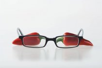 Chiles rojos con un par de gafas - foto de stock