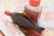 Closeup view of soy sauces and paper package — Stock Photo