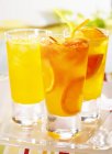 Vista de cerca de tres bebidas de mandarina y pomelo - foto de stock