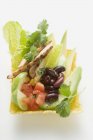 Pollo, verduras, cuñas de lima y cilantro en cáscara de taco sobre superficie blanca - foto de stock