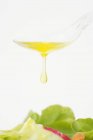 Olio d'oliva sgocciolante da un cucchiaio — Foto stock