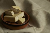 Closeup view of cocoa butter in bowl on cloth — Stock Photo
