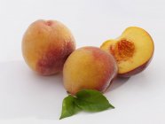 Ripe peaches with leaves — Stock Photo