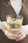 Woman holding decorated glass of water — Stock Photo