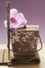 Nahaufnahme eines asiatischen Containers mit Orchidee und Essstäbchen — Stockfoto