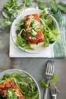 Focaccia mit Tomaten und Brokkoli auf weißen Tellern über Holzoberfläche mit Handtuch — Stockfoto