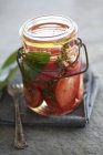 Tomates conservados em jarra sobre toalha com garfo — Fotografia de Stock