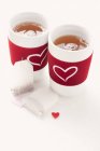 Des sachets de thé et deux tasses de thé décorées de coeurs — Photo de stock