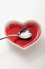Vue surélevée d'un bol en forme de coeur avec une cuillère en forme de coeur — Photo de stock