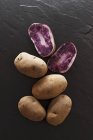Pommes de terre Blauer Schwede entières et coupées en deux — Photo de stock
