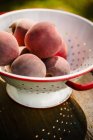 Fresh Peaches in Colander — Stock Photo
