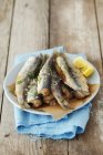 Closeup view of fried herring with salt and lemon — Stock Photo