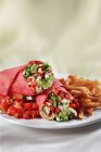 Enveloppement de poulet et légumes au guacamole ; salsa et frites sur assiette blanche — Photo de stock