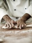 Chef stendere la pasta di gnocchi su un piano di lavoro infarinato — Foto stock