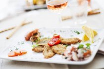 Acciughe fritte - sardinhas empanadas e fritas em prato branco — Fotografia de Stock