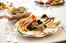Closeup view of mixed starters with prawns, langoustines and carpaccio of tuna and of swordfish — Stock Photo