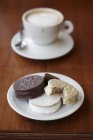 Крупный план шоколадного печенья с чашкой кофе на тарелках — стоковое фото