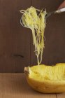 Spaghetti zucca su cucchiaio su sfondo di legno — Foto stock