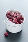Frozen raspberries in white bowls — Stock Photo