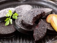 Black pudding slices with apple — Stock Photo
