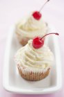 Cupcakes with glace cherries — Stock Photo