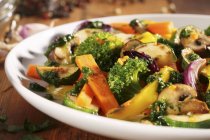 Eine Mischung aus gebratenem Gemüse und Pilzen auf weißem Teller — Stockfoto