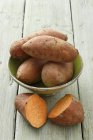 Целый сладкий картофель в миске — стоковое фото