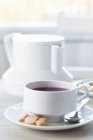 Xícara de chá e um biscoito em forma de docinho — Fotografia de Stock