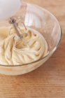 Closeup view of cake mixture in glass bowl with mixer — Stock Photo
