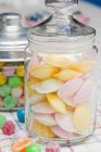 Крупним планом вид на літаючі тарілки і кольорові цукерки в скляних банках — стокове фото