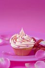 Cupcake com framboesas e pétalas de rosa — Fotografia de Stock