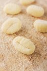Closeup view of fresh Gnocchi with flour on wooden surface — Stock Photo