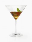 Алкогольный напиток с оливками и мятой на белом фоне — стоковое фото