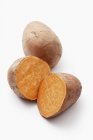 Whole and halved Sweet potatoes — Stock Photo