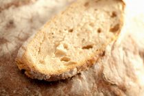 Кусок хлеба поверх буханки — стоковое фото