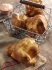 Closeup view of Popovers in wire basket and on cloth — Stock Photo