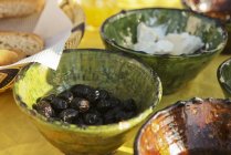Гончарні миски з чорними оливками — стокове фото