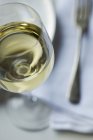 Closeup view of glass of Chardonnay by a place setting — Stock Photo