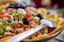Servierschüssel mit marokkanischem Salat mit Tomaten, schwarzen Oliven, Zwiebeln und grünem Paprika — Stockfoto
