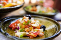 Einzelportionen marokkanischer Salat, zubereitet mit Tomaten, schwarzen Oliven, Zwiebeln und grünem Paprika — Stockfoto
