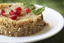 Closeup view of quinoa with mushrooms and pomegranate seeds — Stock Photo