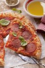 Pizza mit Salami und Basilikum — Stockfoto