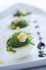 Nahaufnahme von Eiern gefüllt mit Spitzwegerich und bestreut mit Eigelb und Balsamico-Essig — Stockfoto