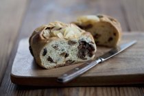 Hefezopf - солодкий хліб з інжиром та родзинками на дерев'яному столі з ножем — стокове фото