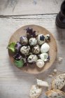 Quail eggs on wooden plate — Stock Photo