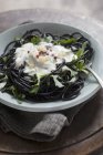 Squid ink spaghetti with arugula — Stock Photo