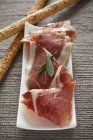 Serrano ham slices with grissini — Stock Photo